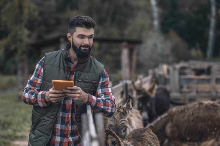 Granjero con una tablet en la mano, soluciones digitales en Latinoamérica.